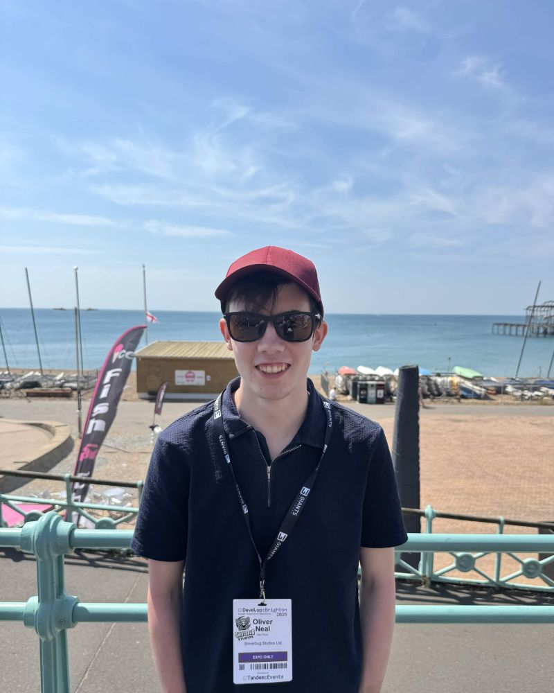 Oliver Neal wearing a Develop:Brighton attendee badge on Brighton seafront